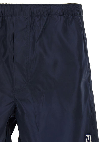 Swim Shorts by Valentino Garavani for men in nylon & mesh blue features a beach chic silhouette, showcasing the signature style of the Men's Nylon & Mesh Swim Shorts.