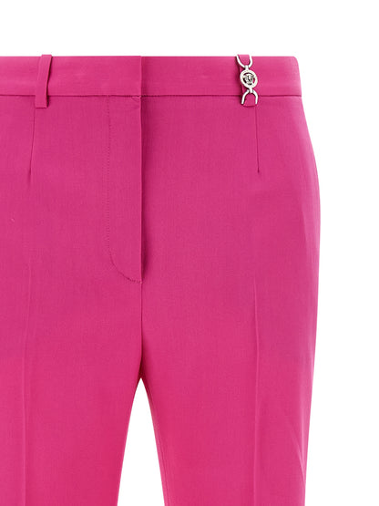 Trousers by Versace for women in virgin wool fuchsia presents a perennial silhouette, meticulously tailored with a straight-leg & flared cut, long finish, and an elegant .