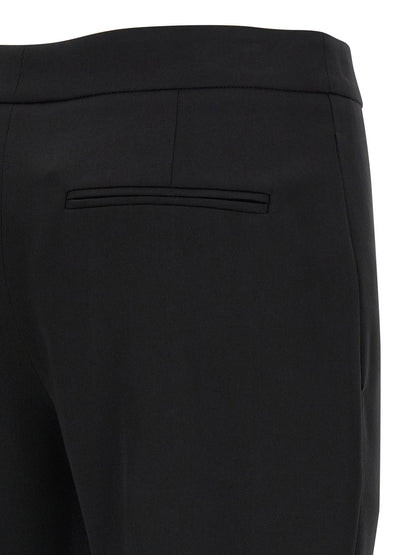 Trousers by Alexander McQueen for women in wool black presents a perennial silhouette, meticulously tailored with a straight-leg & cigarette cut, long finish, and an elegant .