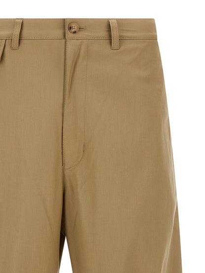 Trousers by Comme Des Garçons for men in cotton beige features a sculptural silhouette, showcasing a sculptural and long with a sophisticated for a sculptural finish.