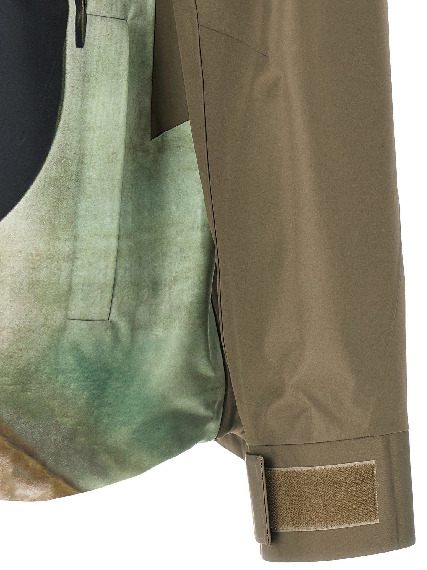 Hooded Windbreaker Jacket by Undercover for men in nylon bicolour, green & print features an enduring silhouette, showcasing technical pockets, hooded & windproof and a sophisticated for a truly enduring aesthetic.