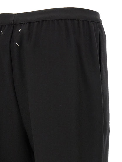Trousers by Maison Margiela for women in virgin wool black presents a perennial silhouette, meticulously tailored with a straight-leg cut, long finish, and an elegant .
