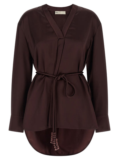 Blouse by Tory Burch for women in satin viscose bordeaux showcases a sublime silhouette, artfully detailed with a sublime v-neck asymmetric neckline and long-sleeve for a sophisticated, sublime finish.