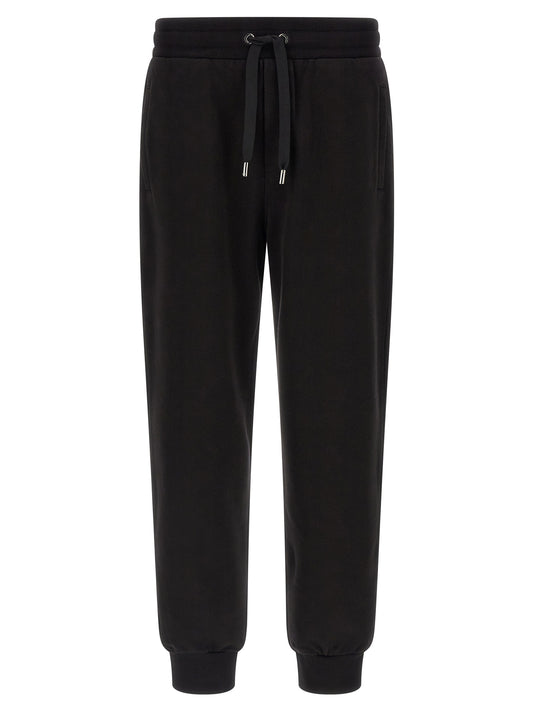 Joggers by Dolce & Gabbana for men in cotton black presents a refined pantology silhouette, artfully defined by a refined pantology , long, and a sophisticated .