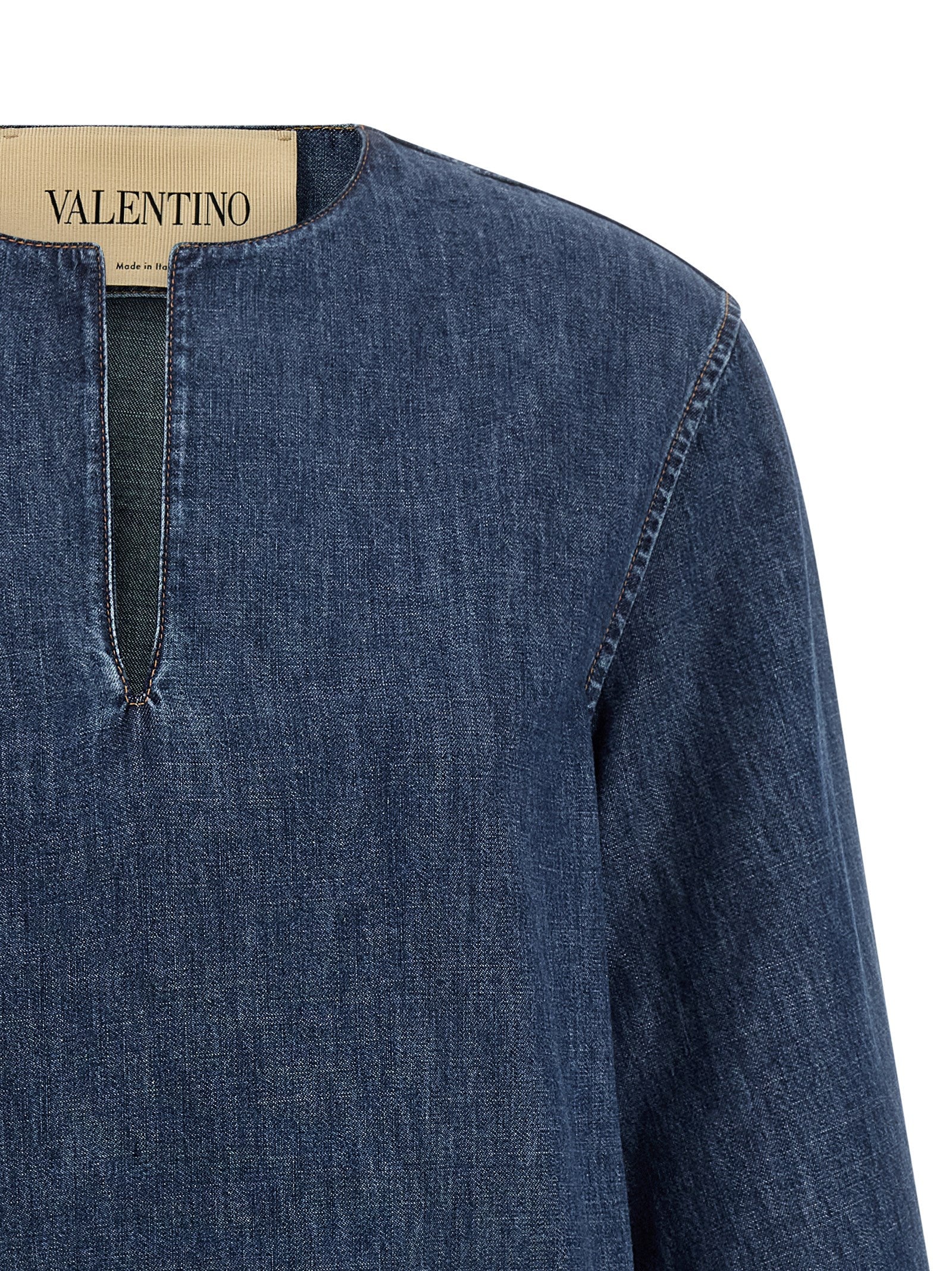 Dress by Valentino Garavani for women in denim cotton blue features a dramatic silhouette, showcasing an elegant v-neck neckline and that flows into a dramatic short.