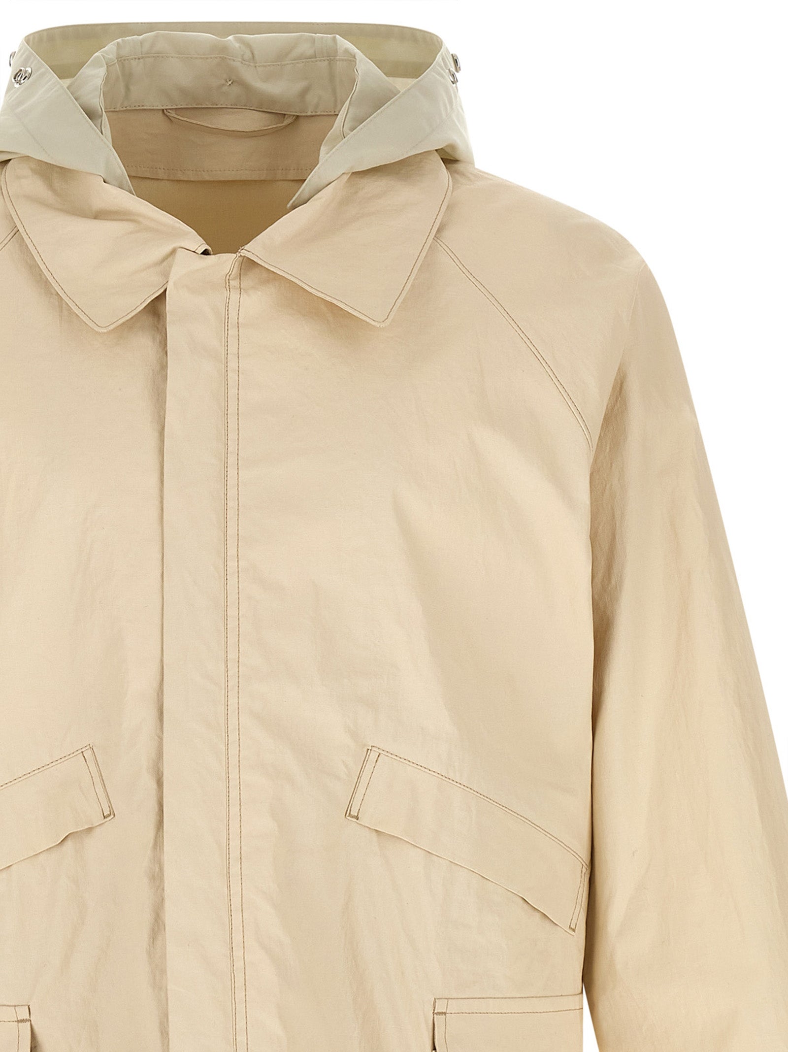 Hooded Windbreaker Jacket by Lemaire for men in polyurethane linen & cotton beige showcases a urban chic silhouette, detailed with a urban chic hooded shirt-collar neckline and functional water-resistant, pockets, hooded & windproof for a polished finish.