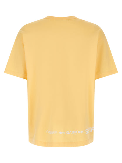 T-Shirt by Comme Des Garçons for men in cotton orange & print showcases a fashionable silhouette, elegantly detailed with a fashionable and crew neckline for a sophisticated, high-fashion look.