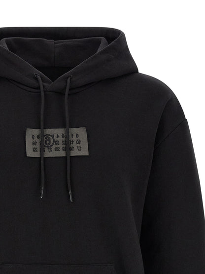 Sweatshirt Hoodie by MM6 Maison Margiela for men in cotton black features an luminous silhouette, showcasing a sophisticated hooded neckline and for a truly luminous look.