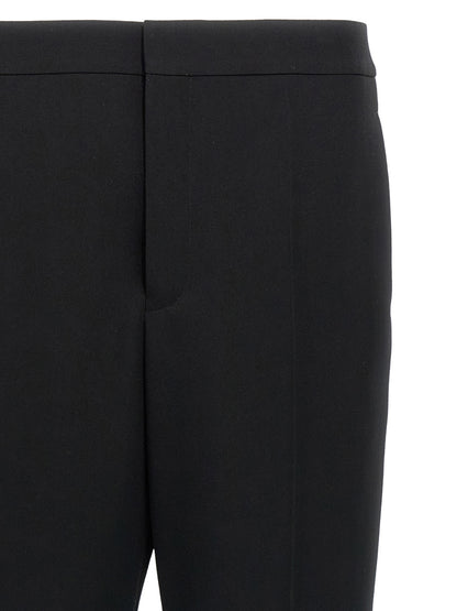 Trousers by Saint Laurent for men in wool black features a sculptural silhouette, showcasing a sculptural and long with a sophisticated for a sculptural finish.