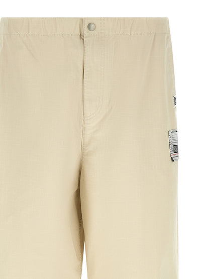 Activewear Pants by Maison Mihara Yasuhiro for men in cotton beige features an sporty tapered-leg, athletic & wide with a long and , expertly finished with for an sporty performance aesthetic.