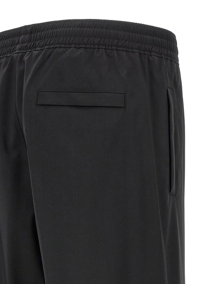Trousers by Givenchy for men in virgin wool black features a artisanal silhouette, showcasing a sophisticated with a long and for a artisanal finish.
