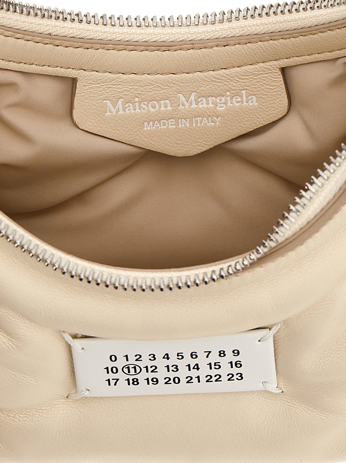 Micro Quilted Shoulder Hobo Bag by Maison Margiela for women in polyester white presents a statuesque silhouette, showcasing a secure zipper and statuesque with versatile shoulder-strap & handle for a sophisticated look.