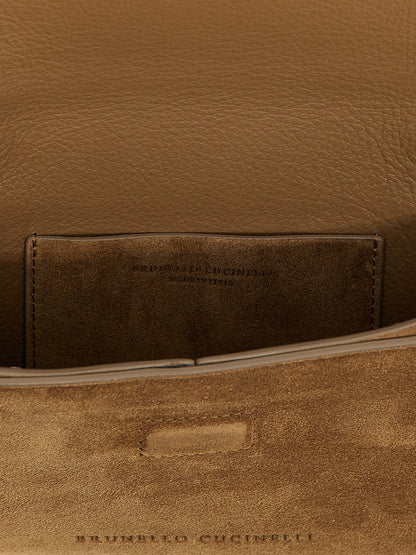 Evening Flap Clutch Handbag by Brunello Cucinelli for women in suede calfskin leather brown features a sculptural silhouette with a secure flap & magnetic, ample , and versatile shoulder-strap for a sculptural finish.