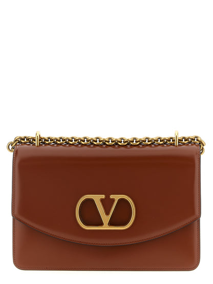 Shoulder Flap Bag by Valentino Garavani for women in nappa calfskin leather brown & signature features a effortless chic silhouette with a secure flap & magnetic, ample , and versatile shoulder-strap for a effortless chic finish.