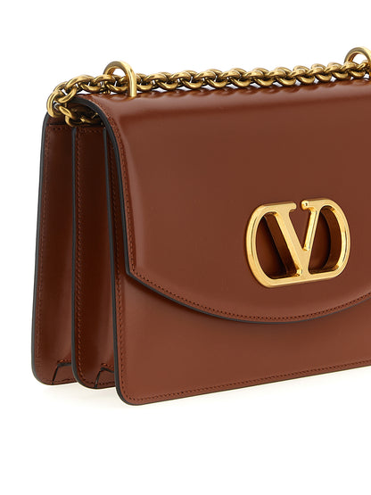 Shoulder Flap Bag by Valentino Garavani for women in nappa calfskin leather brown & signature presents a versatile silhouette, showcasing a secure flap & magnetic and versatile with versatile shoulder-strap for a sophisticated look.
