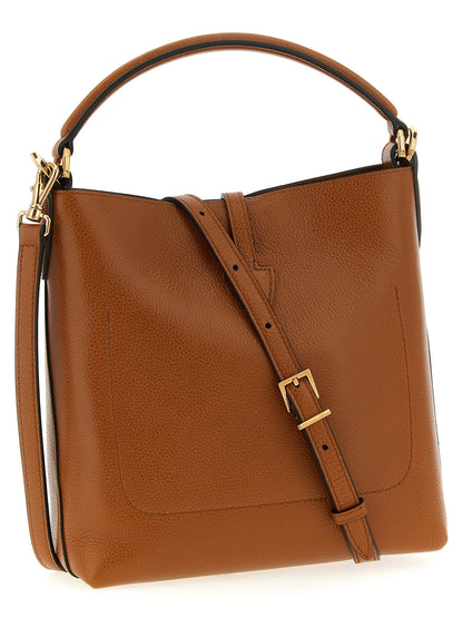 Large Crossbody Bucket Handbag by Tod's for women in calfskin leather brown presents a ornamental silhouette, showcasing a secure snap & button, ample , and versatile crossbody-strap, shoulder-strap, adjustable-strap & handle for a ornamental finish.
