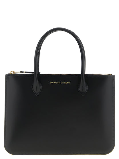 Handbag by Comme Des Garçons for unisex in leather black features an refined silhouette, showcasing a secure zipper, ample , and versatile handle for a sophisticated refined aesthetic.