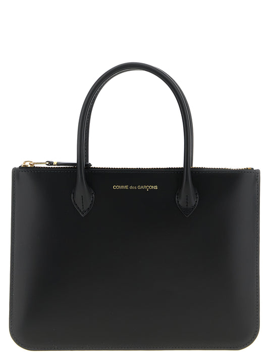 Handbag by Comme Des Garçons for unisex in leather black features an refined silhouette, showcasing a secure zipper, ample , and versatile handle for a sophisticated refined aesthetic.