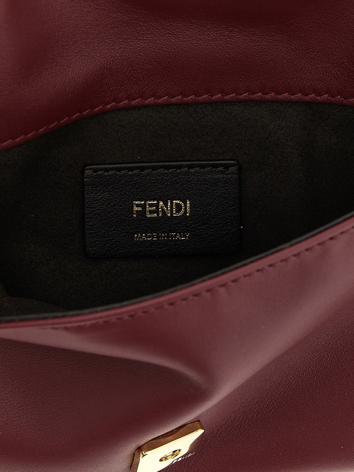 Shoulder Baguette Clutch Handbag by Fendi for women in lamb leather bordeaux & signature showcases a sculptural silhouette, featuring a secure flap & magnetic, ample , and versatile shoulder-strap & wristlet for a sculptural aesthetic.