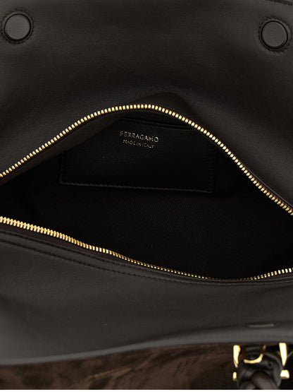 This 2-in-1 Shoulder & Crossbody Handbag by Ferragamo for women in suede leather and brown presents a sculptural silhouette featuring a secure zipper, ample , and versatile crossbody-strap, shoulder-strap, adjustable-strap & handle for a sculptural finish.
