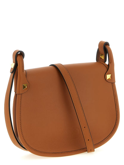 Small Shoulder Flap Bag by Valentino Garavani for women in calfskin leather brown & signature features a effortless chic silhouette with a secure flap & magnetic, ample , and versatile shoulder-strap & adjustable-strap for a effortless chic finish.