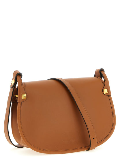 Medium Shoulder Flap Bag by Valentino Garavani for women in calfskin leather brown & signature features a enviable silhouette, showcasing a secure flap & magnetic, ample , and enviable shoulder-strap & adjustable-strap for a enviable finish.