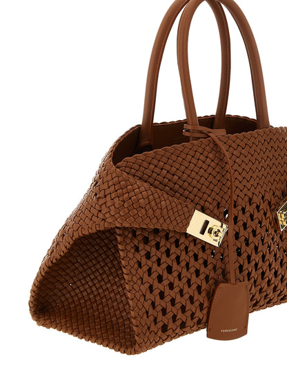 Handbag by Ferragamo for women in calfskin leather brown features an refined silhouette, showcasing a secure , ample , and versatile shoulder-strap, adjustable-strap & handle for a sophisticated refined aesthetic.