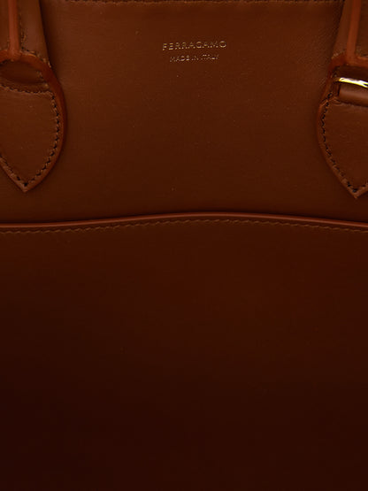 Handbag by Ferragamo for women in calfskin leather brown presents a ornamental silhouette, showcasing a secure , ample , and versatile shoulder-strap, adjustable-strap & handle for a ornamental finish.