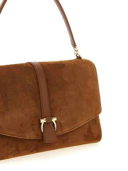 Shoulder Evening Saddle Bag by Ferragamo for women in suede leather brown & signature features a enviable silhouette, showcasing a secure flap & magnetic, ample , and enviable shoulder-strap, handle & adjustable-strap for a enviable finish.