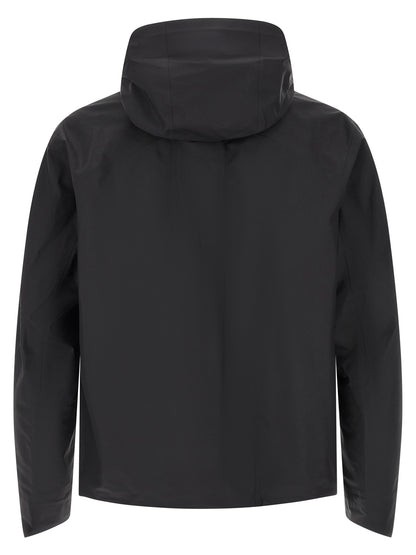 Hooded Windbreaker Jacket by Arc'teryx Veilance for men in nylon black features an perennial silhouette with a refined hooded high-neck neckline and perennial breathable-design, water-resistant, windproof & hooded for a sophisticated weather-resistant look.
