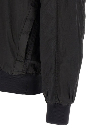 Hooded Bomber Jacket by Stone Island for men in nylon black features a dramatic silhouette, showcasing a sophisticated and distinctive pockets & hooded for a dramatic aesthetic.