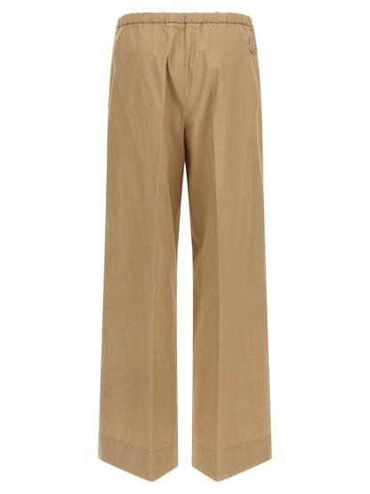 Trousers by Moncler for women in cotton beige presents a perennial silhouette, meticulously tailored with a straight & wide cut, long finish, and an elegant .