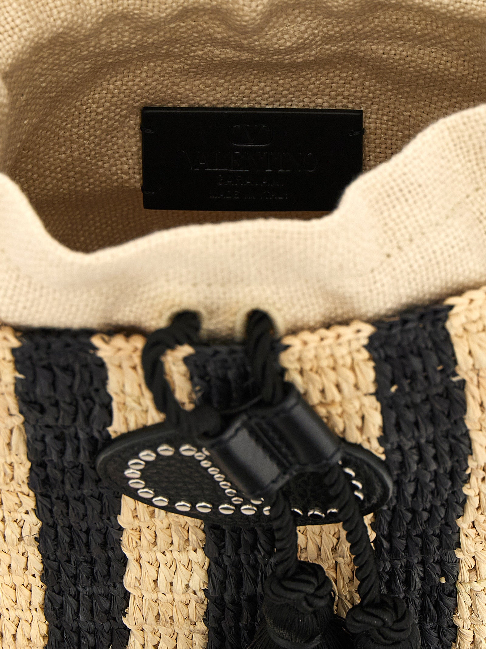 Small Shoulder Bucket Pouch Bag by Valentino Garavani for women in grained leather black, patterned, signature & striped showcases a statuesque silhouette, artfully detailed with a secure drawstring, organized , and versatile shoulder-strap & adjustable-strap for a statuesque look.