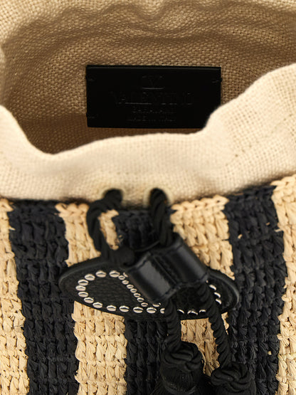 Small Shoulder Bucket Pouch Bag by Valentino Garavani for women in grained leather black, patterned, signature & striped showcases a statuesque silhouette, artfully detailed with a secure drawstring, organized , and versatile shoulder-strap & adjustable-strap for a statuesque look.