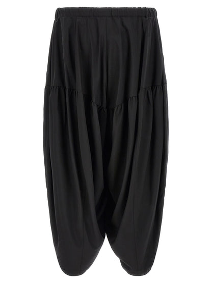 Trousers by Comme Des Garçons for men in polyester black features a sculptural silhouette, showcasing a sculptural and long with a sophisticated for a sculptural finish.