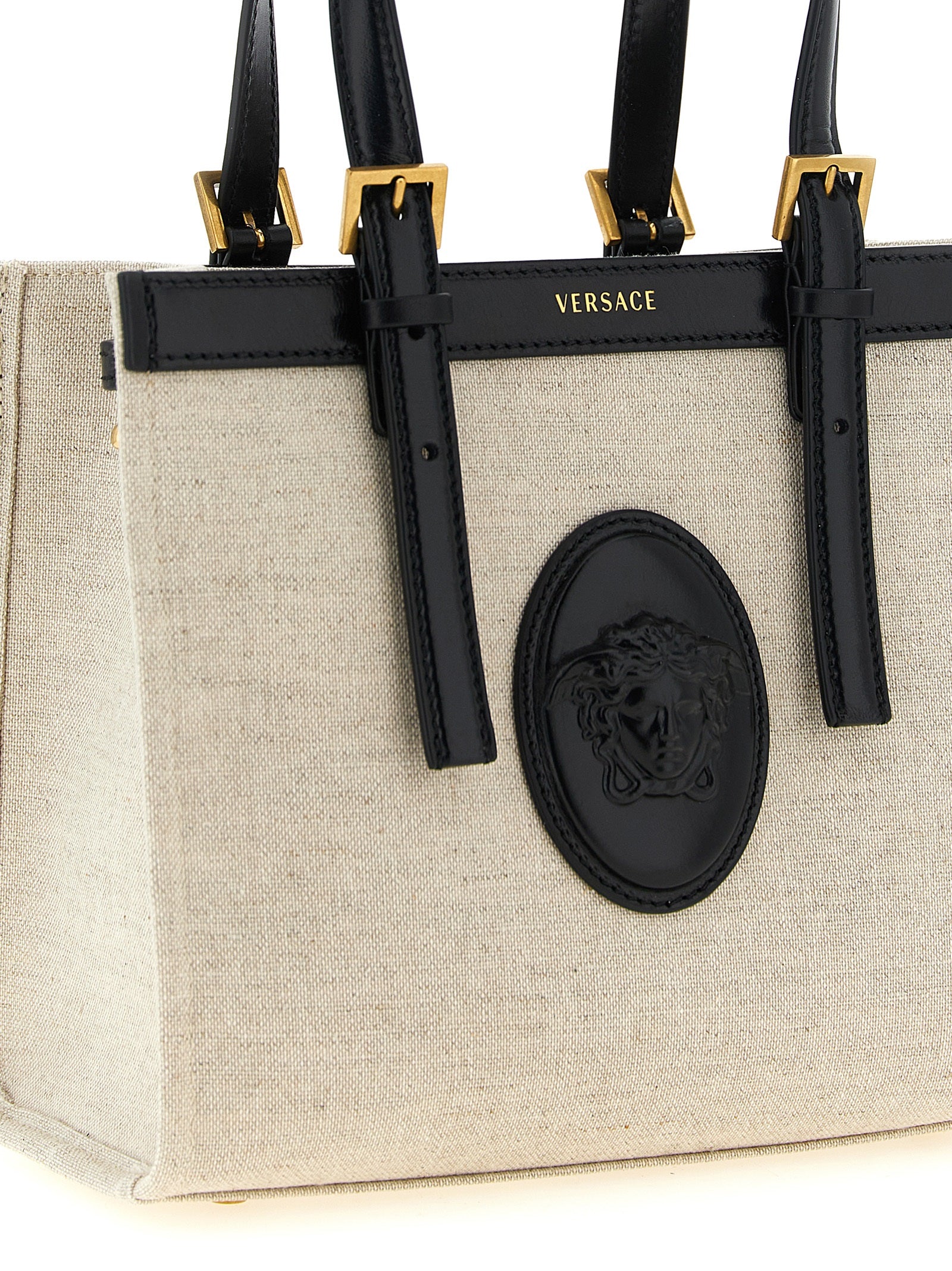 Mini Crossbody Satchel Tote Bag by Versace for women in suede calfskin leather & cotton canvas beige & print features a distinguished Crisp Medusa Riviere Suede Calfskin Leather & Cotton Canvas Mini Crossbody Satchel Tote Bag design, complete with a secure snap & button, ample , and versatile crossbody-strap, shoulder-strap, adjustable-strap & handle for a distinguished look.