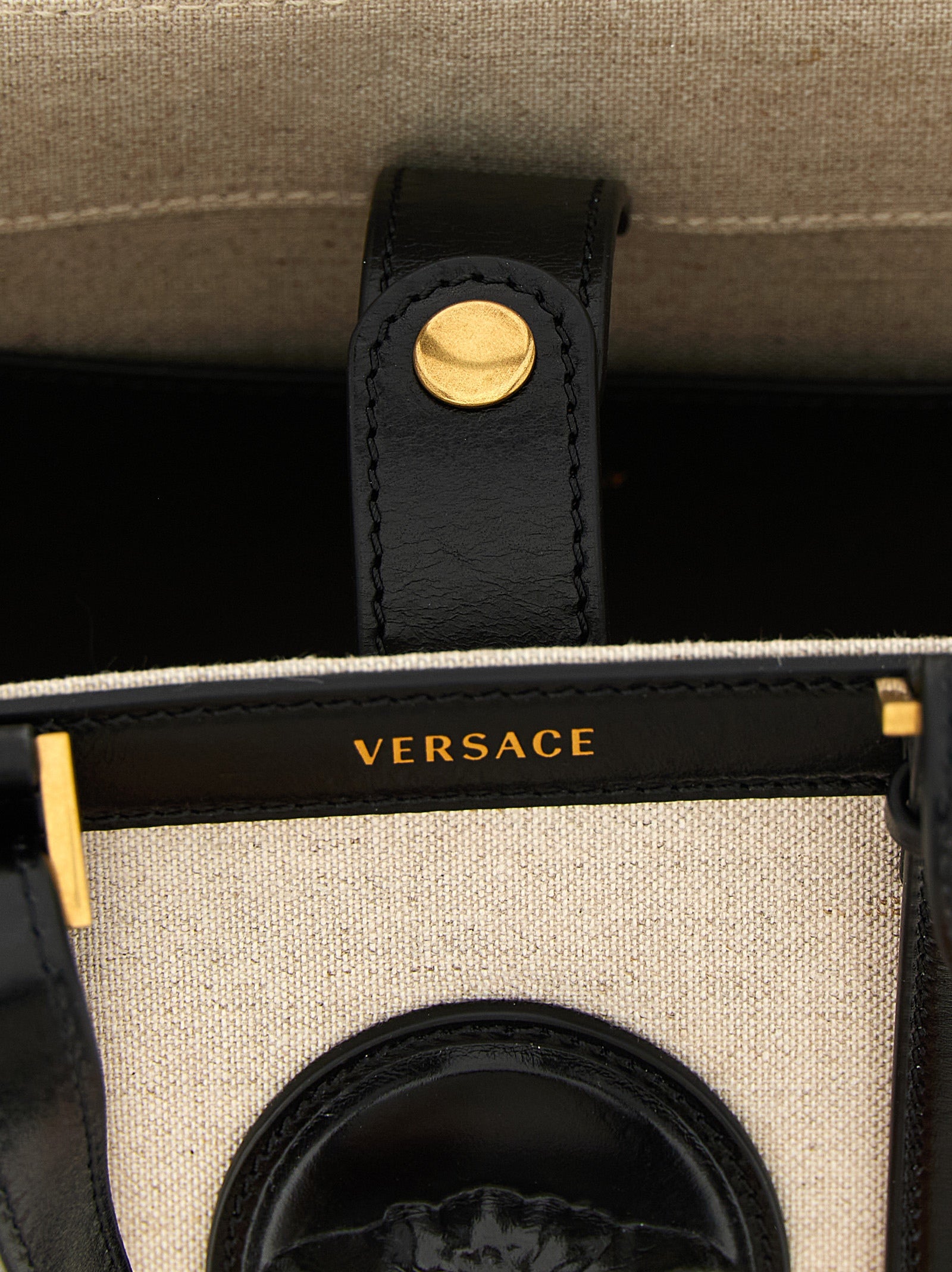 Mini Crossbody Satchel Tote Bag by Versace for women in suede calfskin leather & cotton canvas beige & print features an utilitarian-chic silhouette, showcasing the Crisp Medusa Riviere Suede Calfskin Leather & Cotton Canvas Mini Crossbody Satchel Tote Bag design with a secure snap & button, ample , and versatile crossbody-strap, shoulder-strap, adjustable-strap & handle.