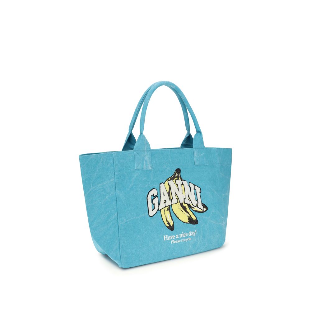Medium Tote Shoulder Bag by Ganni for women in cotton blue, signature & print showcases a enviable silhouette, artfully detailed with a secure zipper, organized single-compartment, and versatile handle for a enviable look.