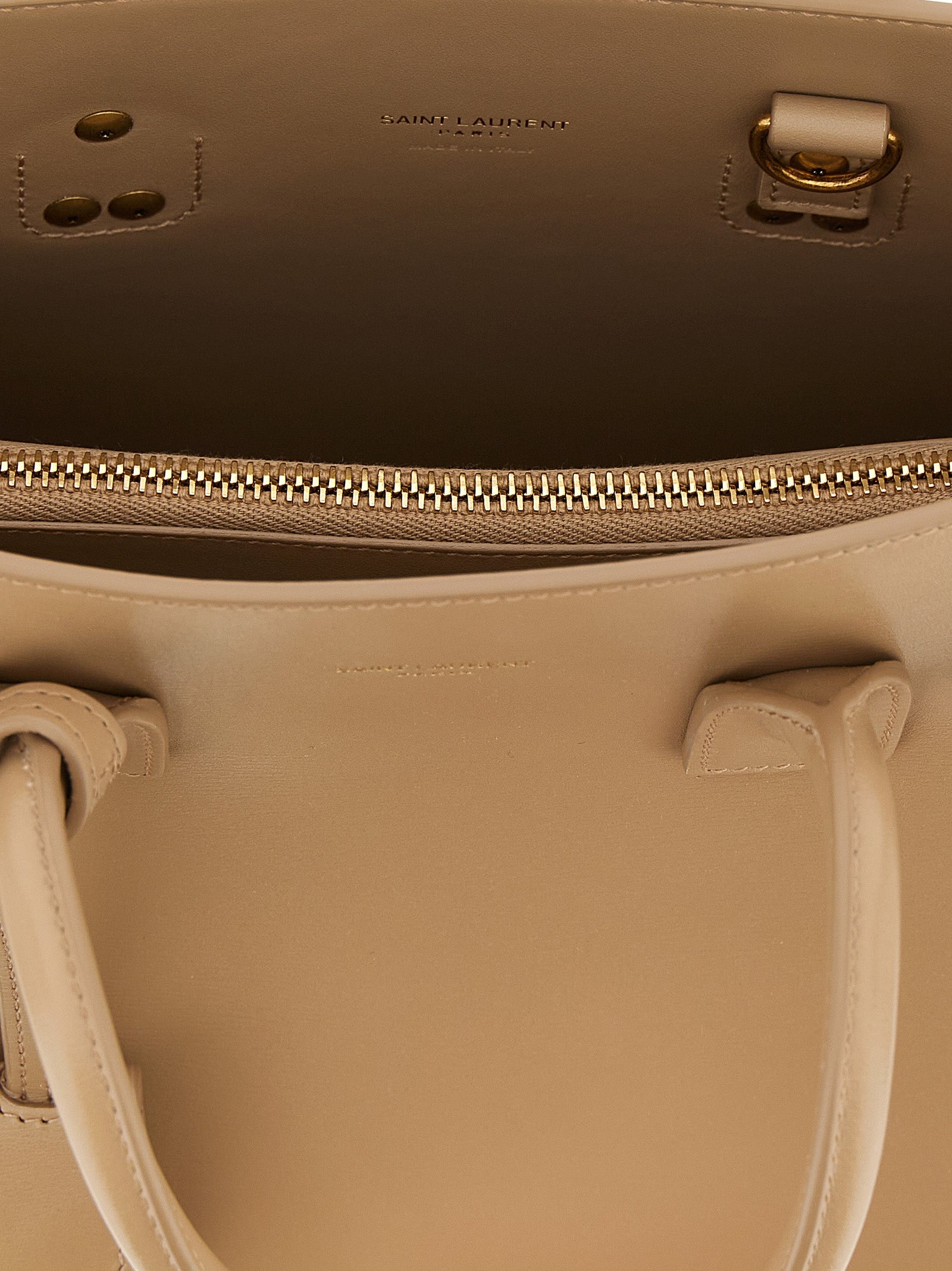 This Handbag by Saint Laurent for women in calfskin leather and beige presents a sculptural silhouette featuring a secure , ample , and versatile shoulder-strap, handle & adjustable-strap for a sculptural finish.