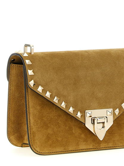 Small 2-in-1 Shoulder & Crossbody Envelope Handbag by Valentino Garavani for women in suede calfskin leather beige, gold & signature features an multi-faceted design with a secure snap, ample , and versatile crossbody-strap, shoulder-strap & adjustable-strap for a multi-faceted finish.
