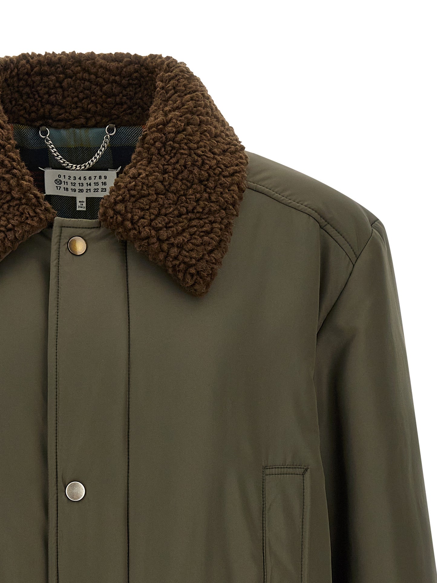 This Parka by Maison Margiela for men in polyester bicolour, green, olive, silver & tartan presents a utilitarian silhouette, meticulously detailed with pockets and a utilitarian for a sophisticated, weather-ready look.