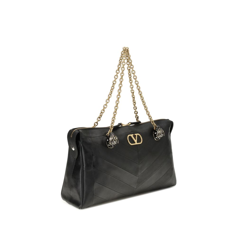 Medium Shoulder Bag by Valentino Garavani for women in nappa & suede leather black, chevron, signature & patchwork showcases a enviable silhouette, artfully detailed with a secure zipper & button, organized , and versatile shoulder-strap, handle & adjustable-strap for a enviable look.