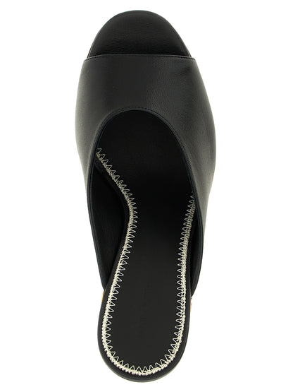 Wedge Mules Sandals by Magda Butrym for women in calfskin leather black showcases a sculptural silhouette as Women's Calfskin Leather Wedge Mules Sandals, defined by a sculptural wedge and sculptural open toe style for a sculptural look.