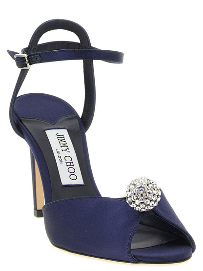 Stiletto Ankle Strap Sandals by Jimmy Choo for women in leather satin & crystal navy features an effortlessly chic silhouette from the Women's Leather Satin & Crystal Stiletto Ankle Strap Sandals collection, showcasing a effortlessly chic stiletto and elegant peep toe style.