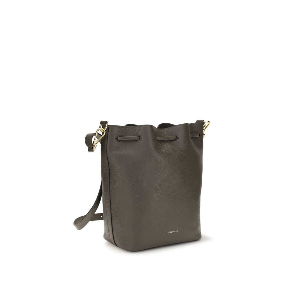 Bucket Handbag by Coccinelle for women in bos taurus calf grained leather brown, gold & signature features an effortlessly chic silhouette, showcasing a secure zipper & drawstring, effortlessly chic external-pockets, and versatile adjustable-strap & handle.