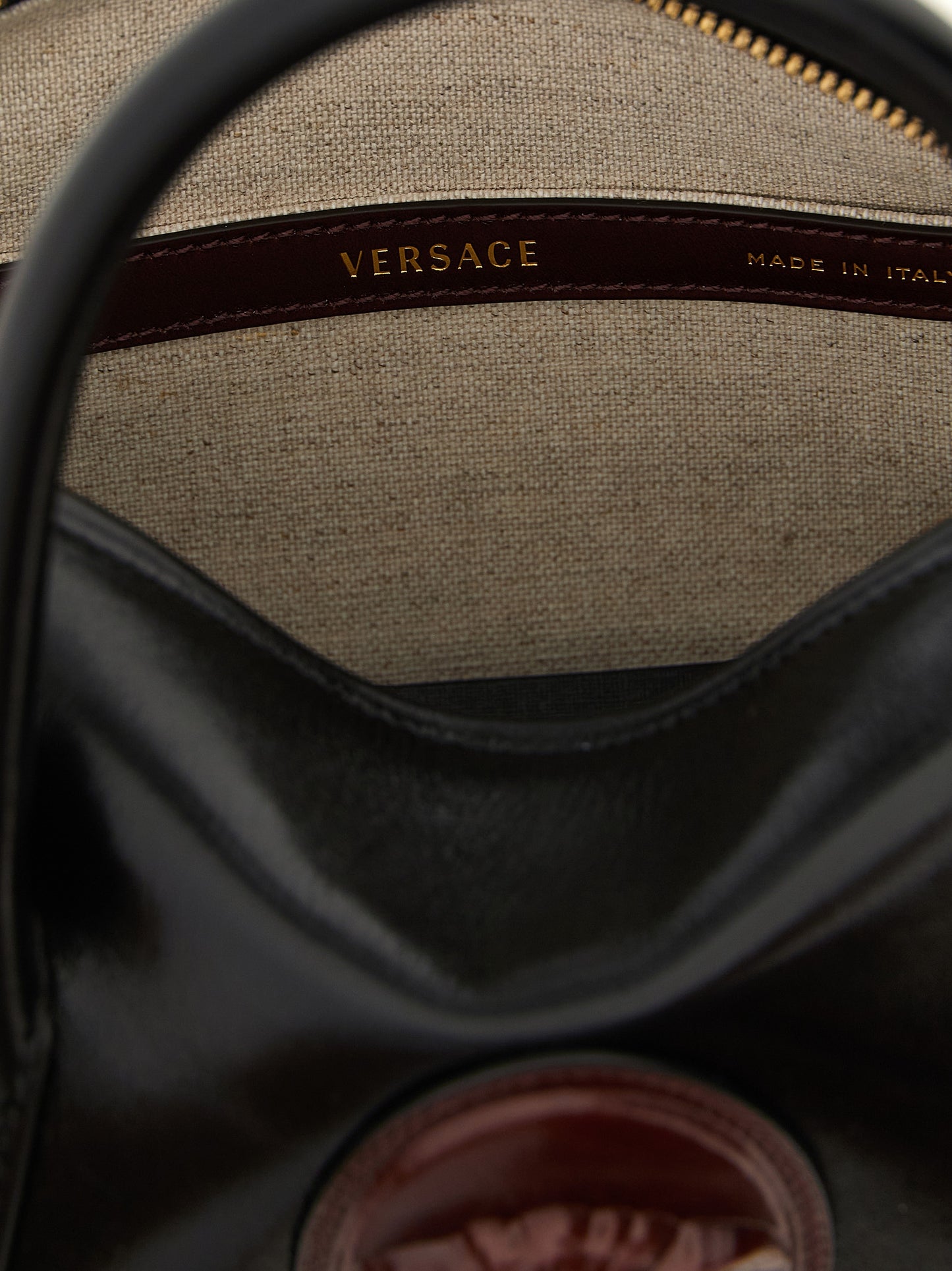 Small Handbag by Versace for women in calfskin leather black, burgundy & gold features an refined silhouette, showcasing a secure , ample , and versatile shoulder-strap, handle & detachable-strap for a sophisticated refined aesthetic.