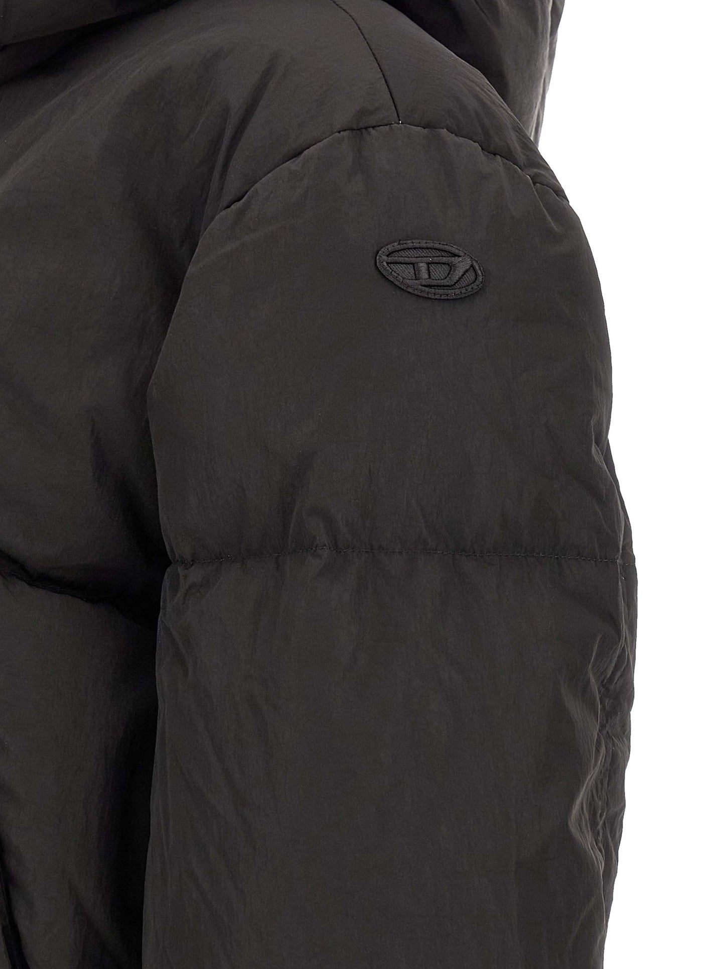 This Hooded Puffer Jacket by Diesel for women in polyamide black exhibits a edgy silhouette, meticulously detailed with functional pockets, hooded & insulated and a edgy for a edgy finish.