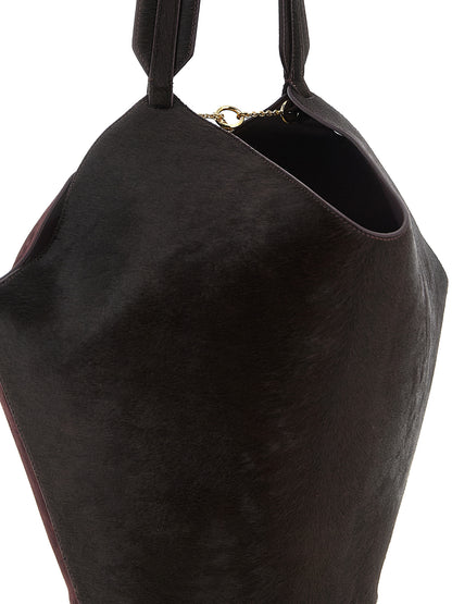 Small Shopper Tote Bag by Khaite for women in calfskin leather bordeaux & gold features a jet-set sophisticated Lotus Calfskin Leather Small Shopper Tote Bag design with a secure , ample , and versatile handle for a jet-set sophisticated finish.