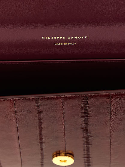 Evening Envelope Clutch Handbag by Giuseppe Zanotti for women in polyamide bordeaux, burgundy & gold showcases a sculptural silhouette, featuring a secure flap, magnetic & button, ample , and versatile shoulder-strap & detachable-strap for a sculptural finish.