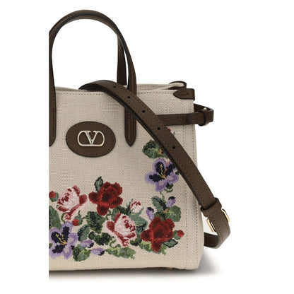 Small 2-in-1 Shoulder & Crossbody Bag by Valentino Garavani for women in grained leather & linen beige, natural, floral & signature features an effortlessly chic silhouette with a secure zipper & buckle, ample single-compartment, and versatile crossbody-strap, shoulder-strap, handle, adjustable-strap & detachable-strap for effortlessly chic everyday luxury.